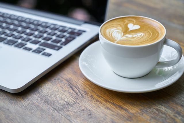 Een laptop met een goede kop koffie, ter illustratie van onze pijlers in de praktijk